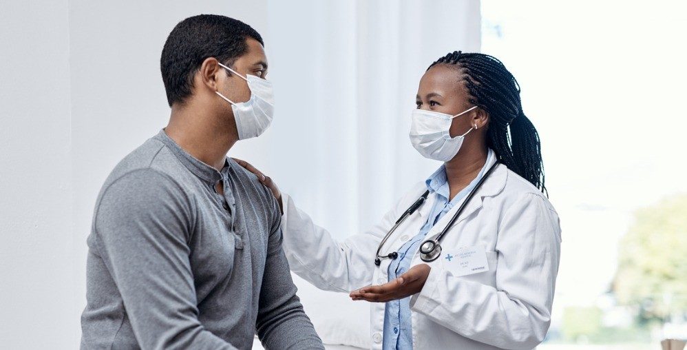 Doctor and patient talking wearing masks