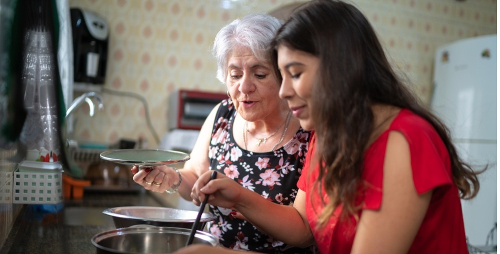 Grandmother teaching her granddaughter how to cook