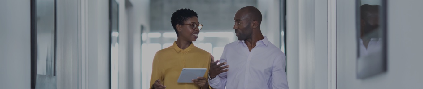 African American man and woman talking in office hallway