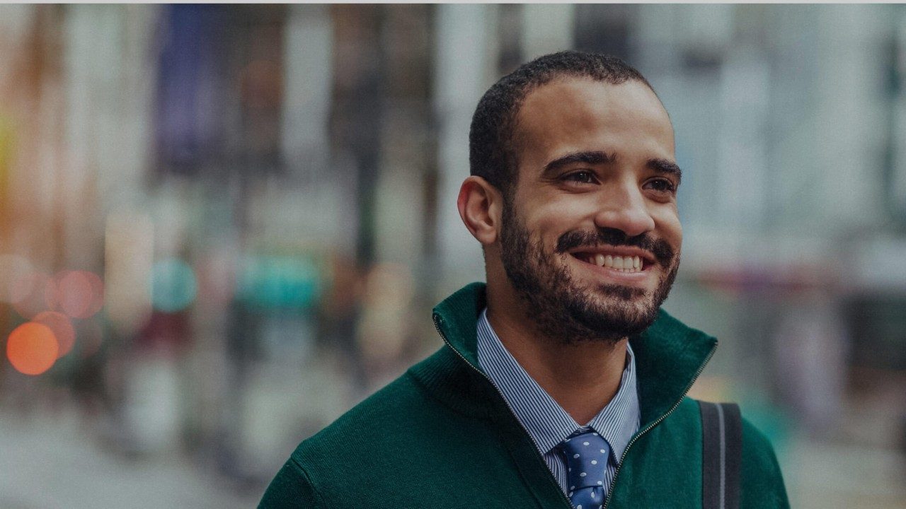 Man on city street smiling