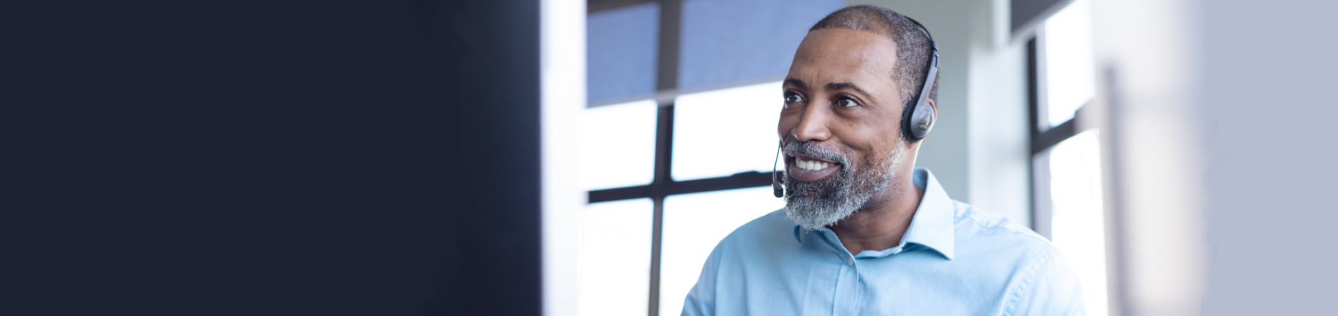 Older man smiling and talking on headset