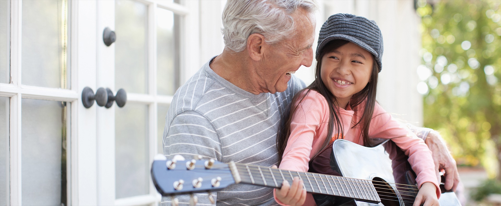Grandfather and granddaughter playing the guitar