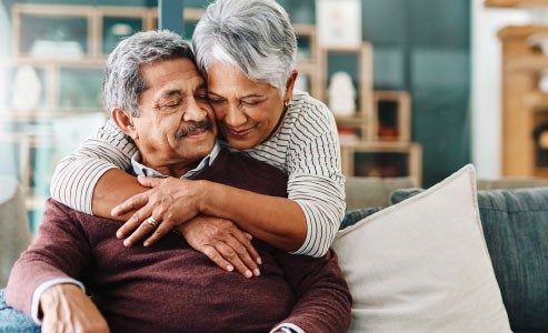 Couple sitting on couch hugging