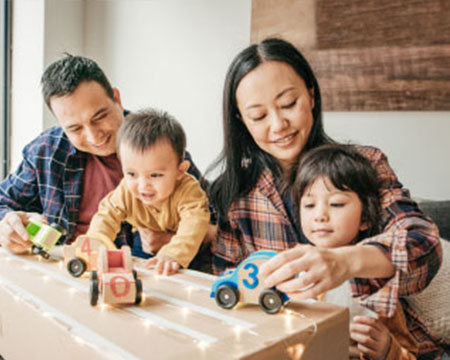 young family of four playing with toys at home