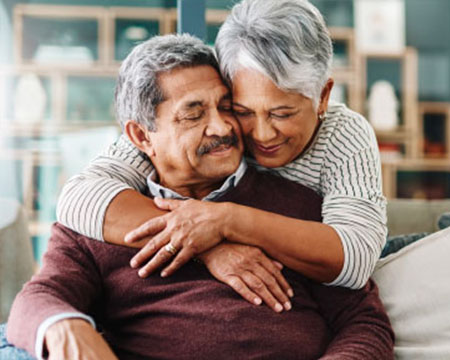 senior couple hugging on couch