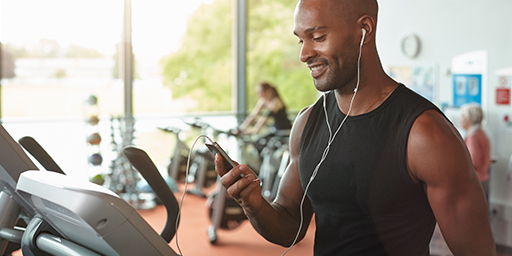 man at the gym and he is looking at his phone