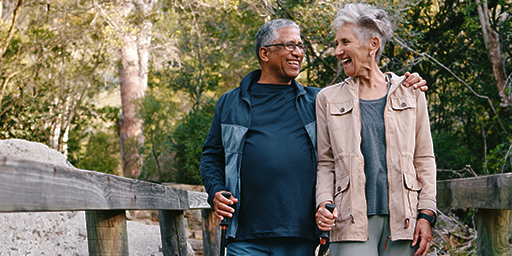 a senior couple walking outside and smiling