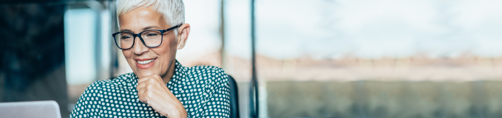 Older woman smiling and sitting at computer