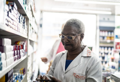 Old woman pharmacist looking at prescriptions