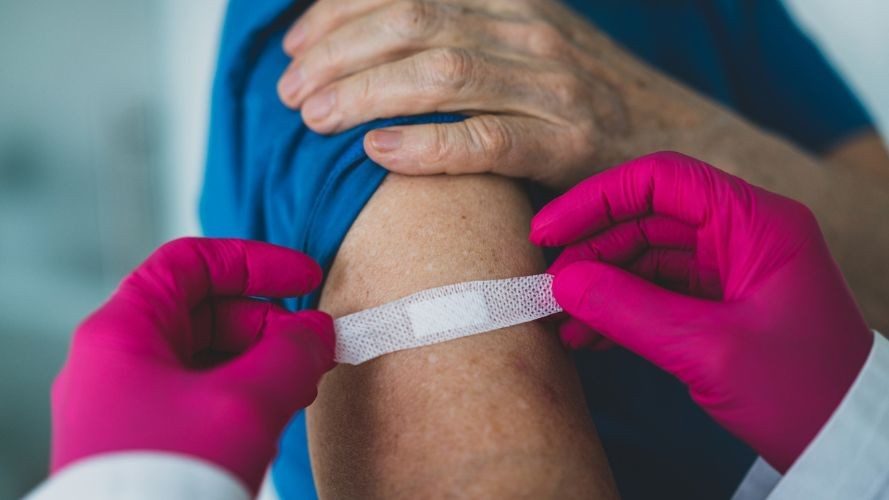 doctor-places-band-aid-over-vaccination-site-on-patient-arm