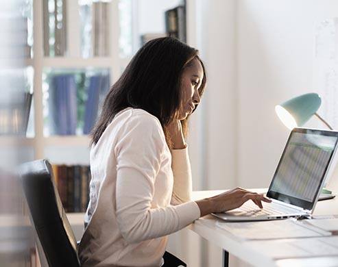 Mixed race businesswoman using laptop