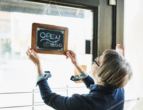 Woman hanging business open sign